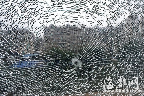 钢化玻璃窗裂成“蜘蛛网”，窗上孔洞清晰可见